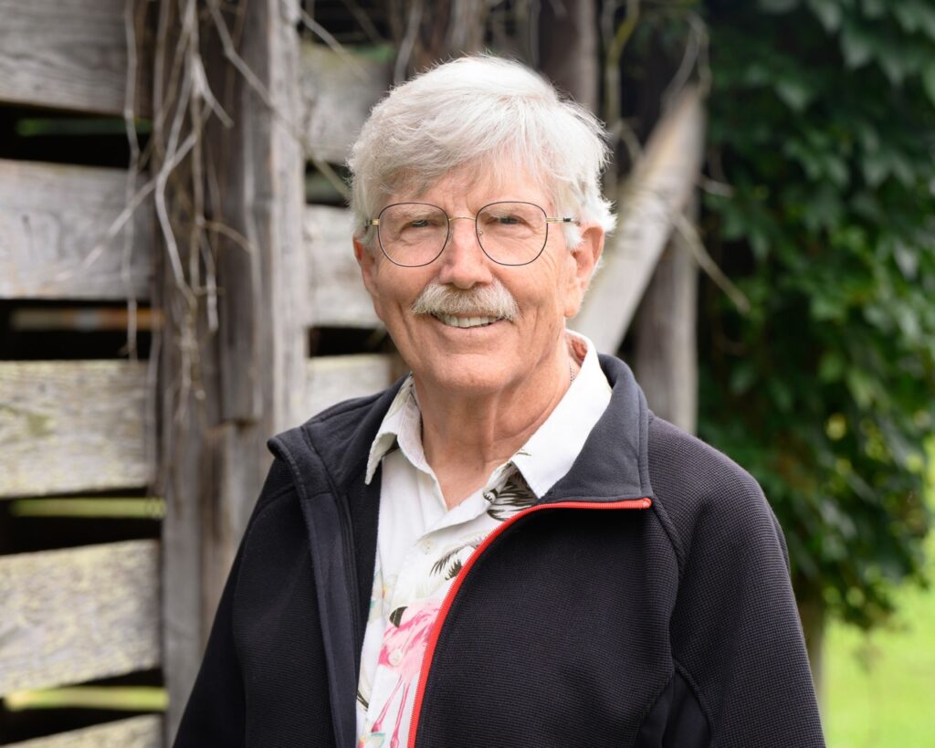 Close-up of Jay Bryan in front of old farm building